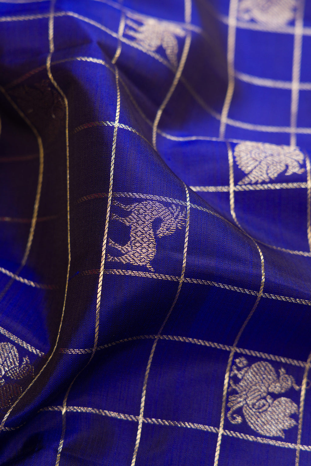 Close up of Royal Blue Kanchipuram Silk Saree with Checked design on the body and Zari Border.  displaying folds