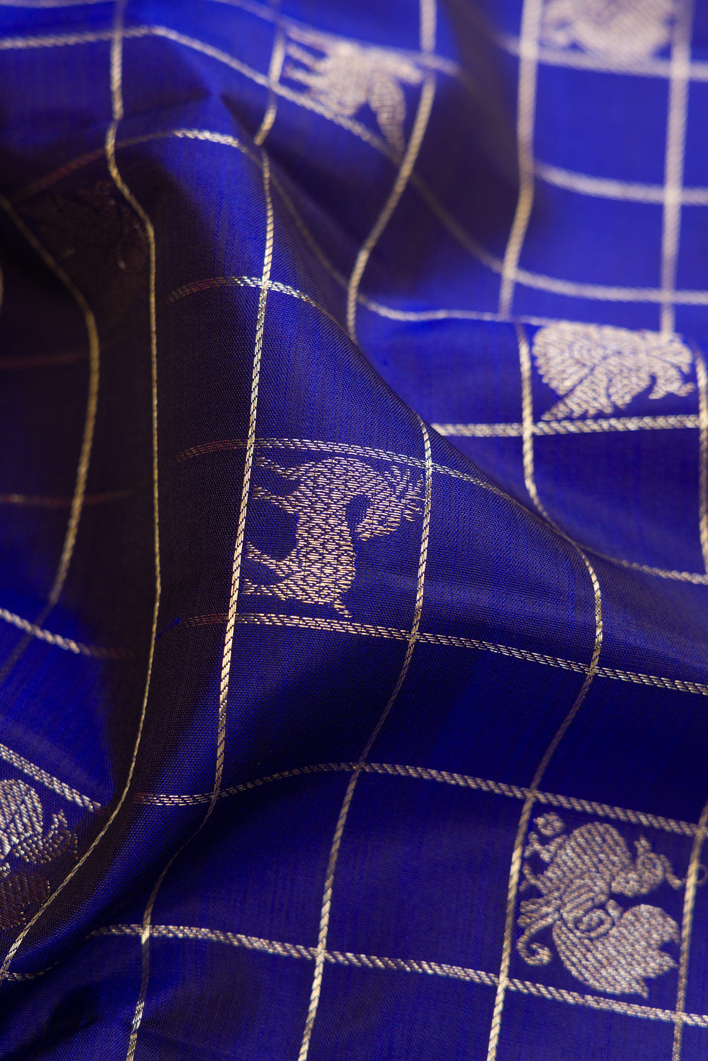 Close up of Royal Blue Kanchipuram Silk Saree with Checked design on the body and Zari Border.  displaying folds
