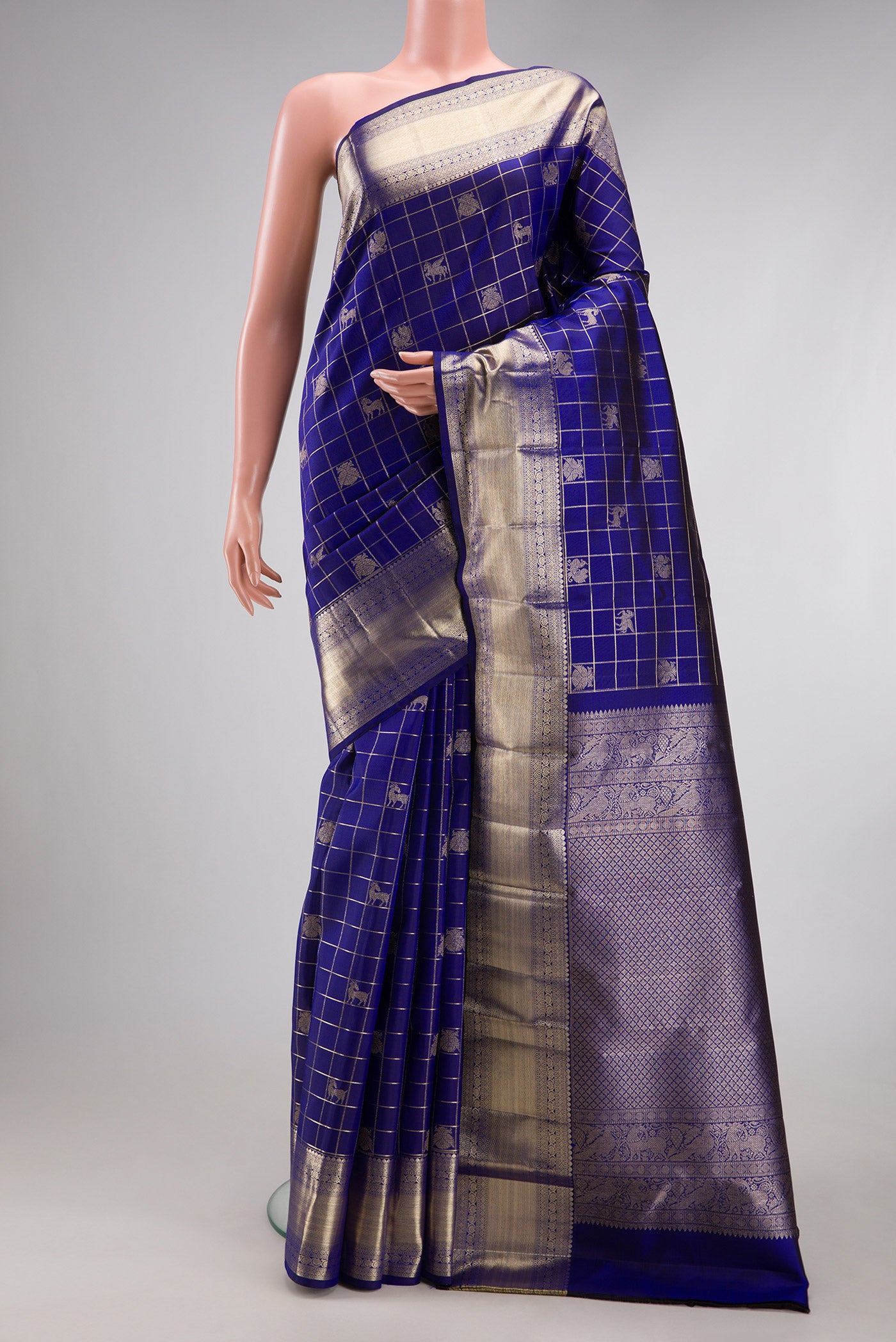 Royal Blue Kanchipuram Silk Saree with Checked design on the body and Zari Border.  displayed on a mannequin