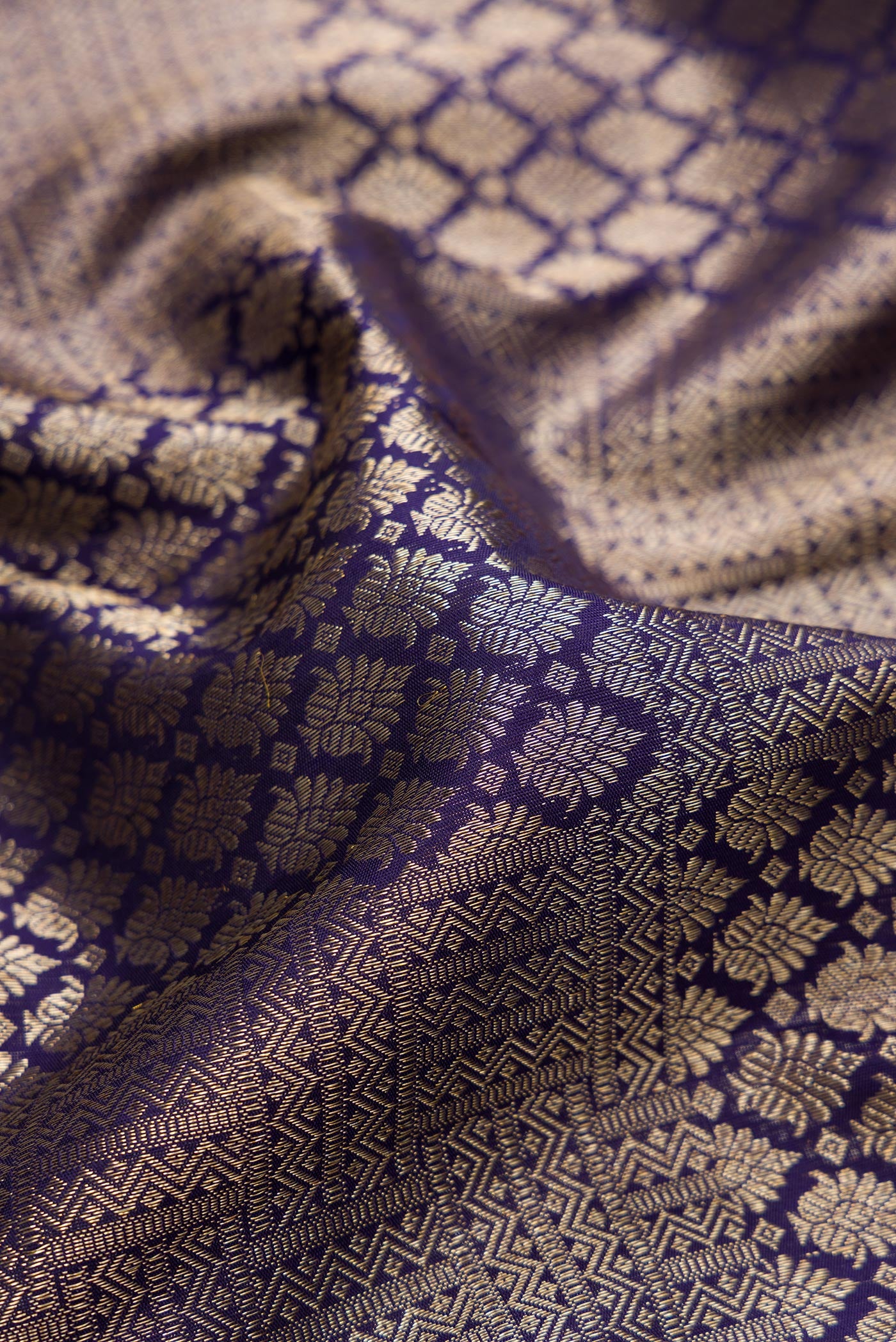 Close up of Navy Blue Kanchipuram Silk Saree with Zari Brocade on the body and Zari Border.  displaying folds