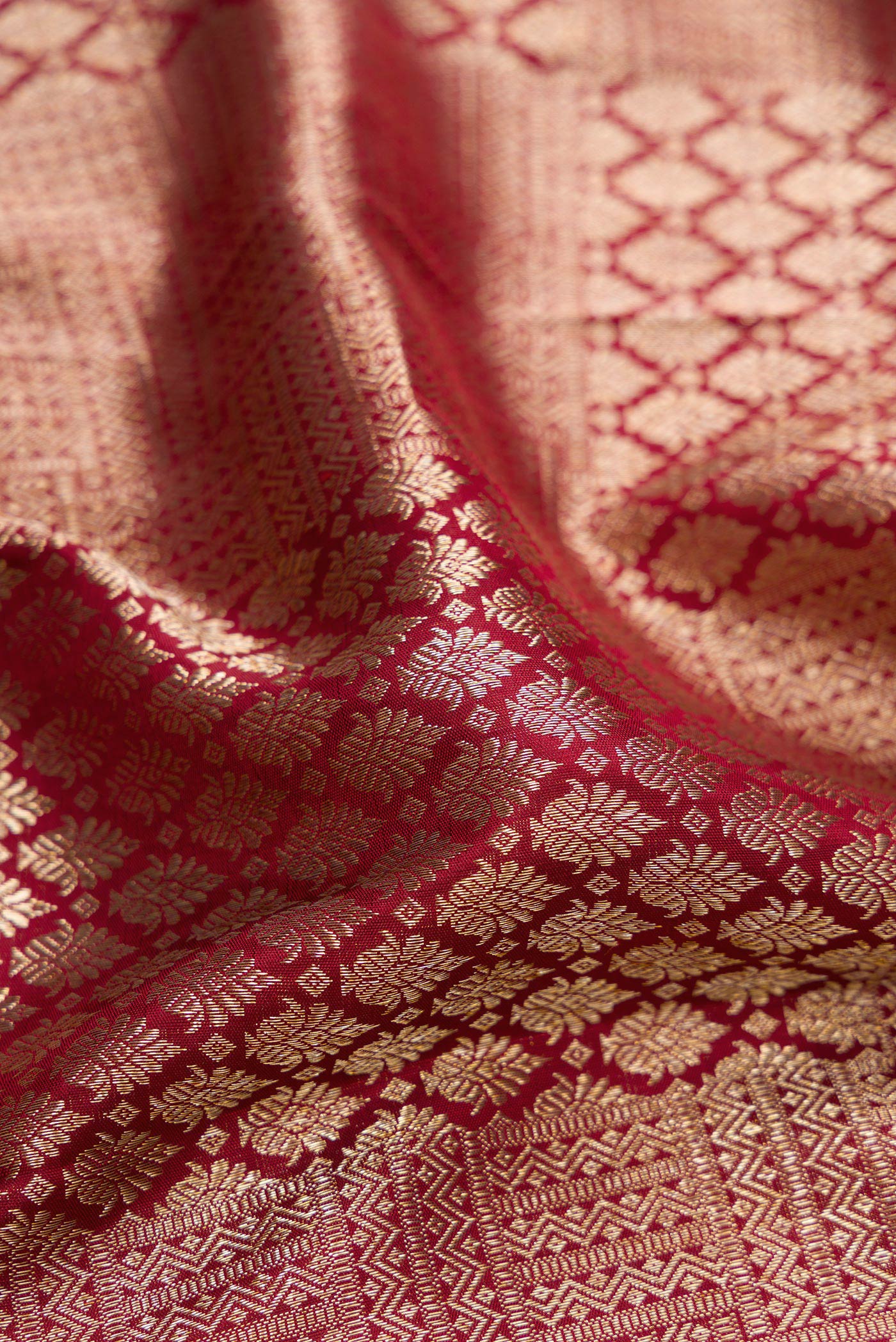 Close up of Maroon Kanchipuram Silk Saree with Zari Brocade on the body and Zari Border.  displaying folds