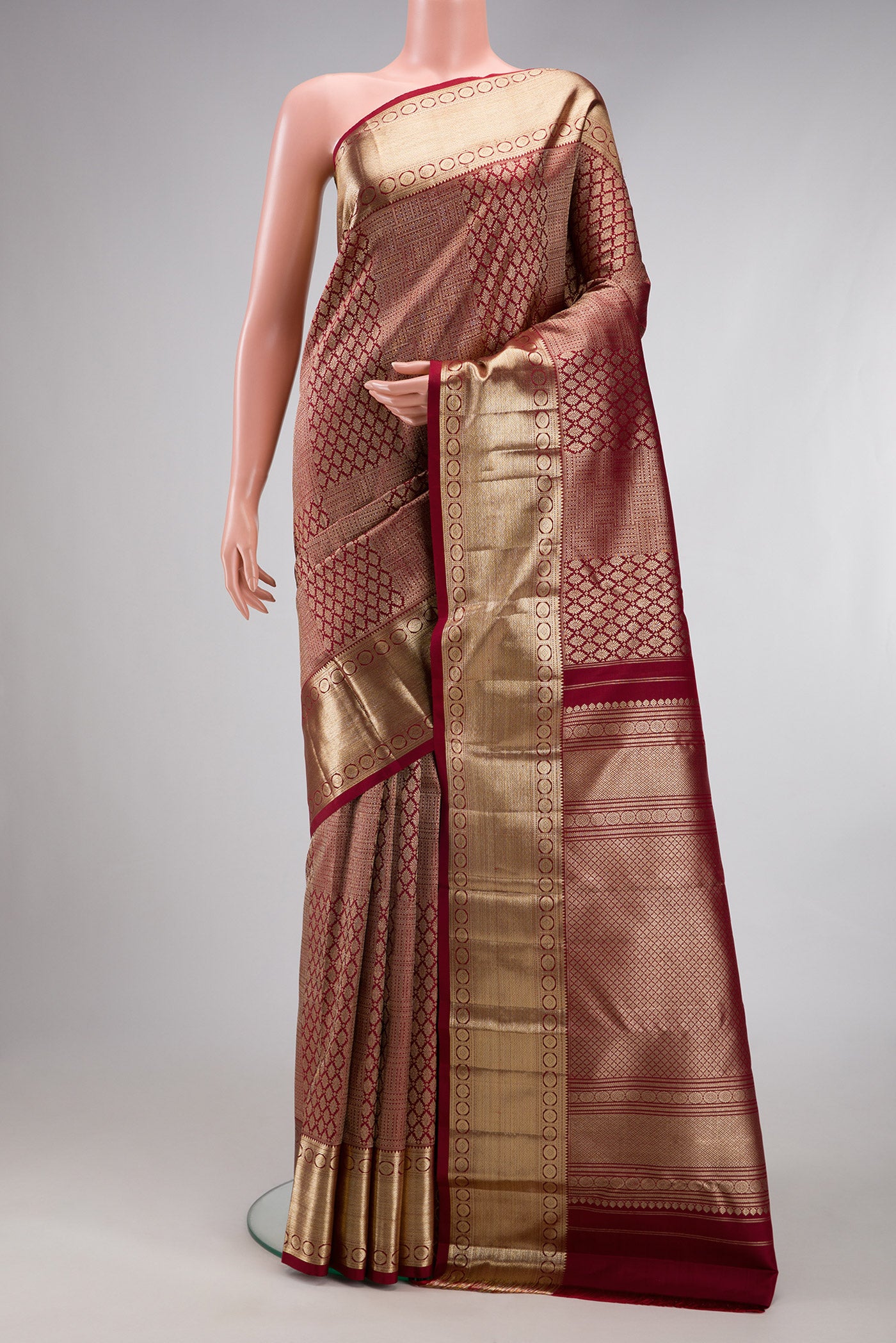 Maroon Kanchipuram Silk Saree with Zari Brocade on the body and Zari Border.  displayed on a mannequin