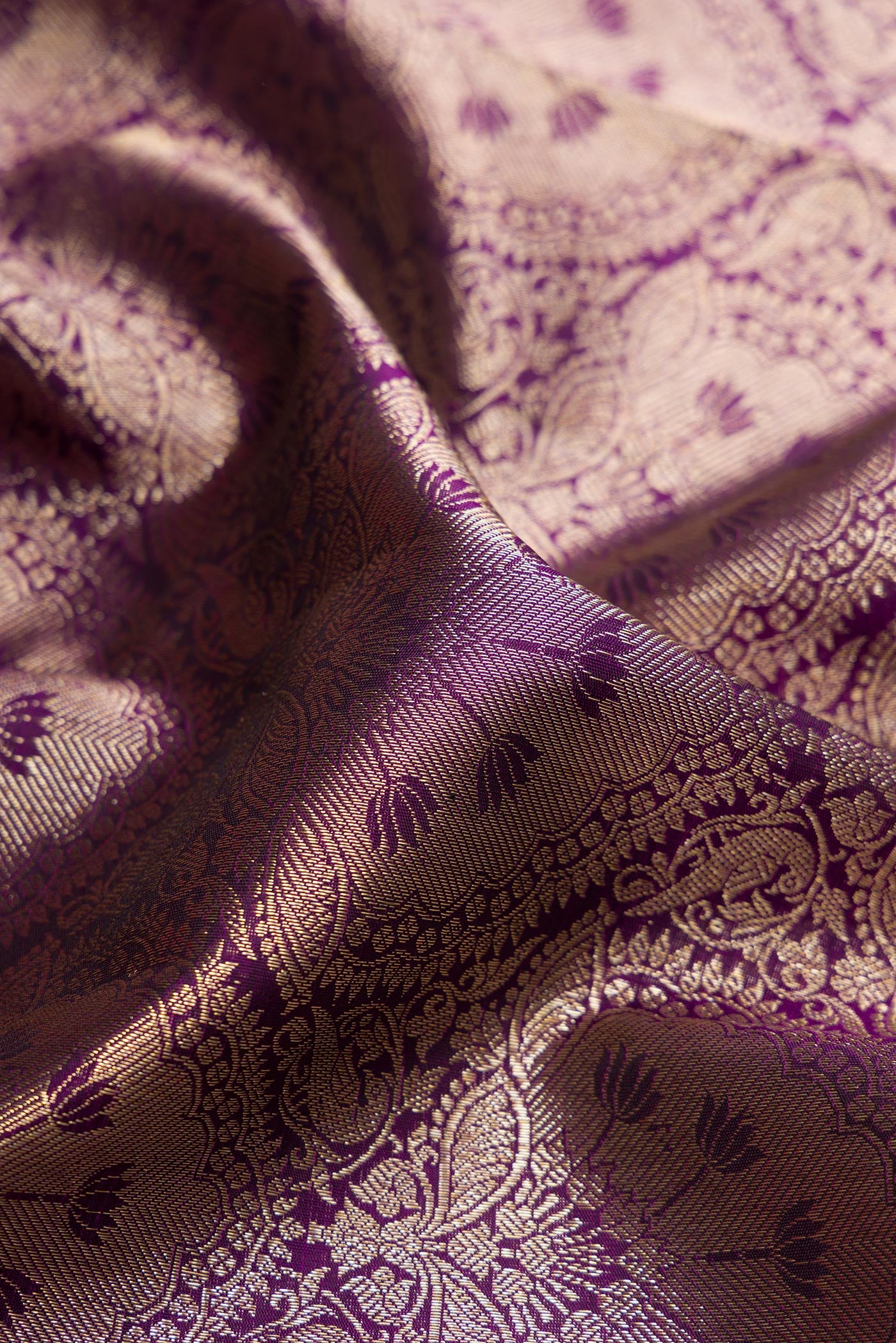 Close up of Purple Dual Tone Kanchipuram Silk Saree with Zari Brocade on the body and Zari Border.  displaying folds