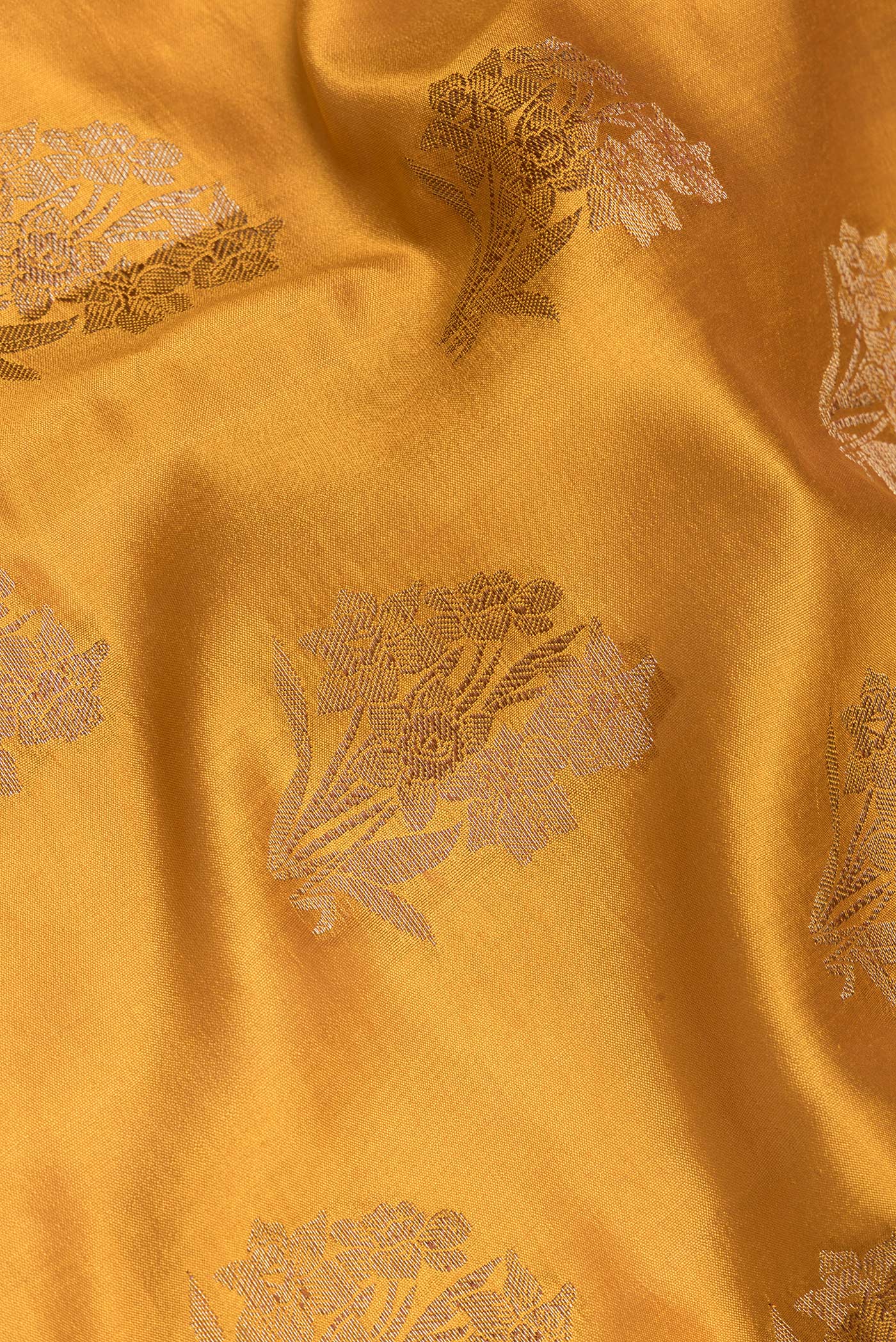 Close up of Mustard Tussar Silk Saree with Zari Butta on the body and Zari Border.  displaying folds