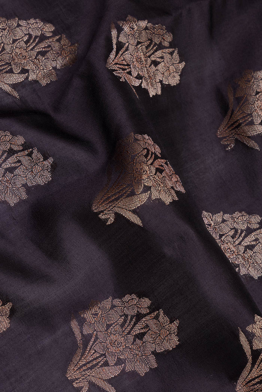 Close up of Black Tussar Silk Saree with Zari Butta on the body and Zari Border.  displaying folds