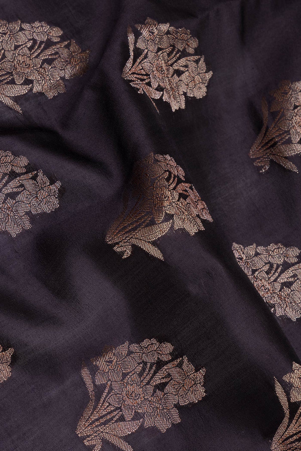 Close up of Black Tussar Silk Saree with Zari Butta on the body and Zari Border.  displaying folds