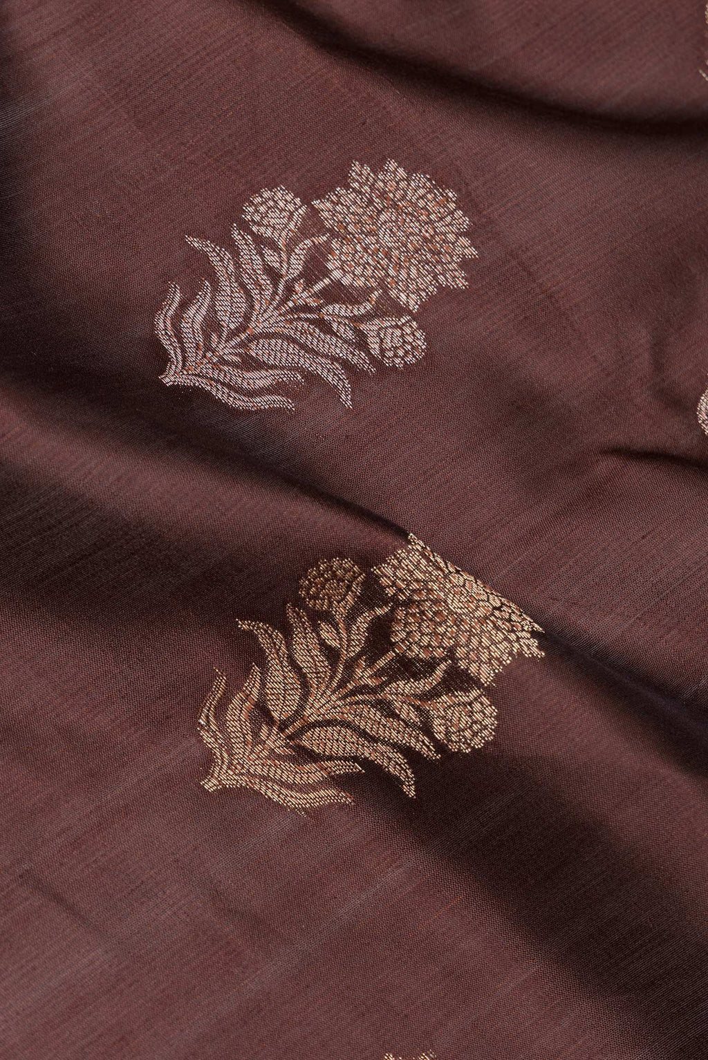Close up of Brown Tussar Silk Saree with Zari Butta on the body and Zari Border.  displaying folds