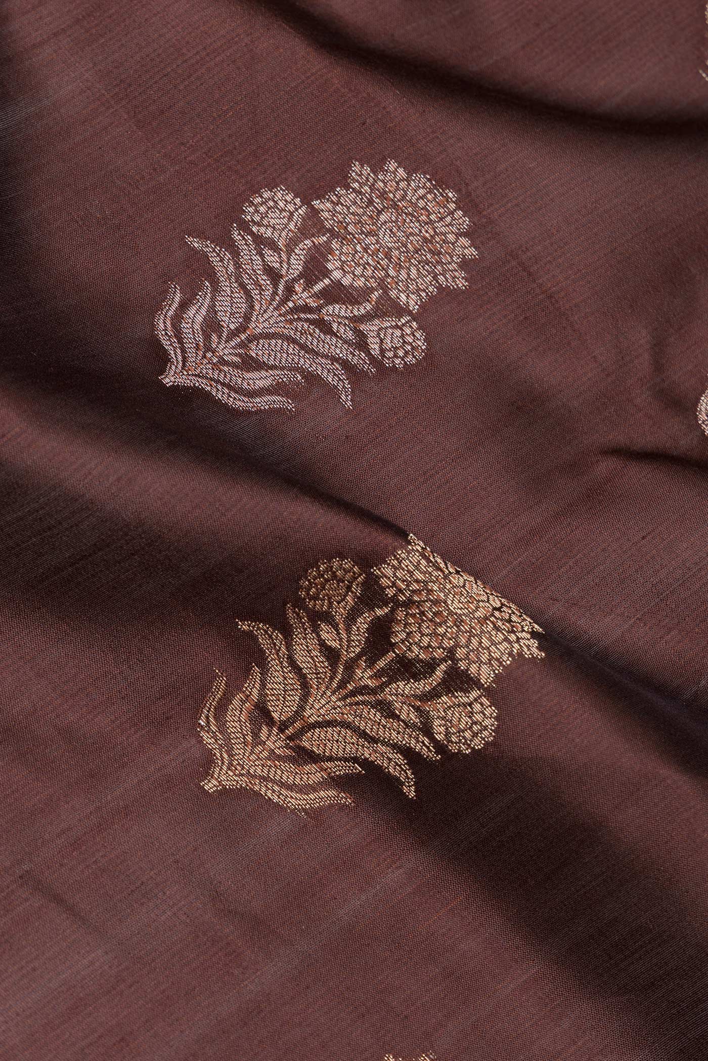 Close up of Brown Tussar Silk Saree with Zari Butta on the body and Zari Border.  displaying folds