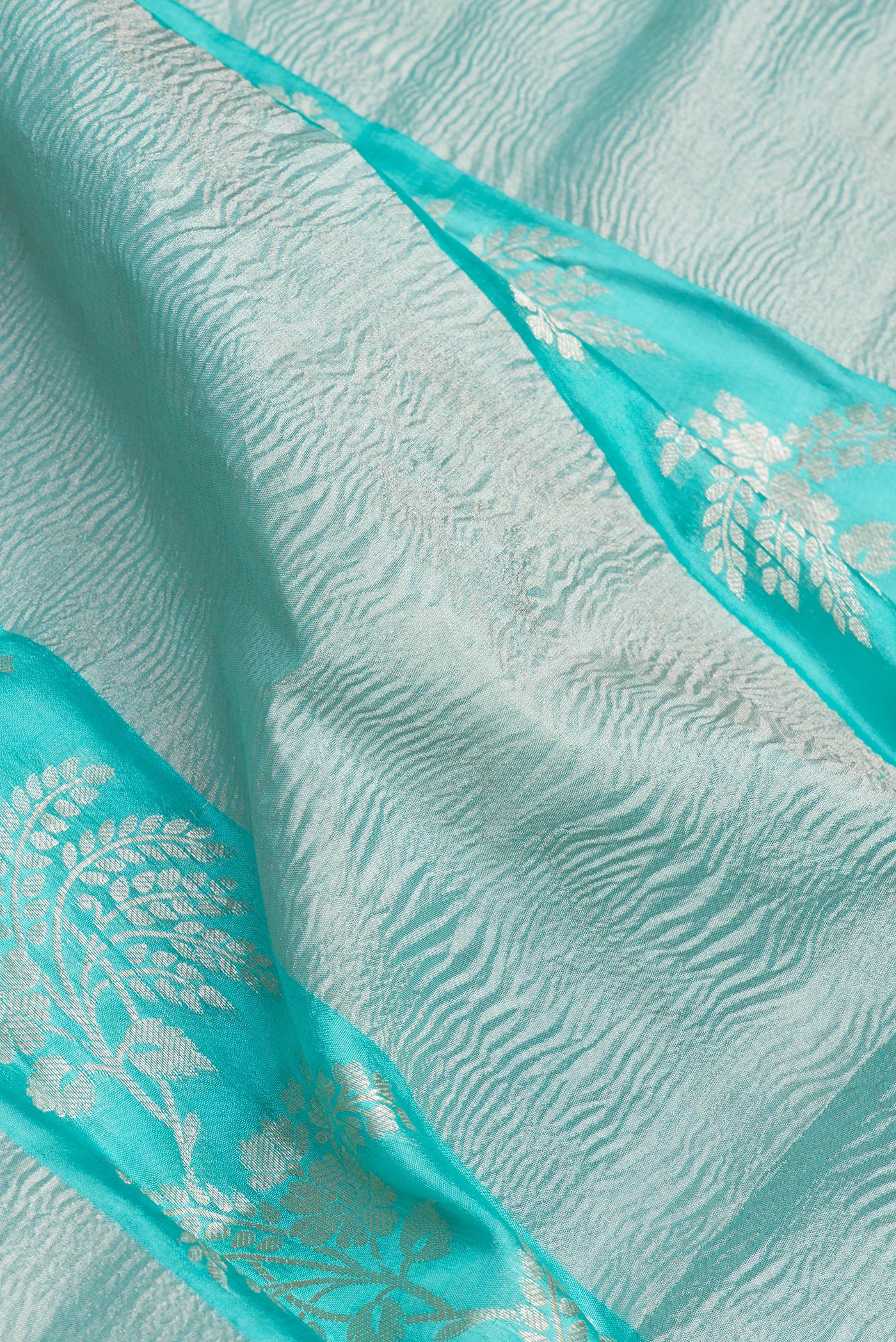 Close up of Sky Blue Tussar Silk Saree with Zari Brocade on the body and Fancy Border.  displaying folds