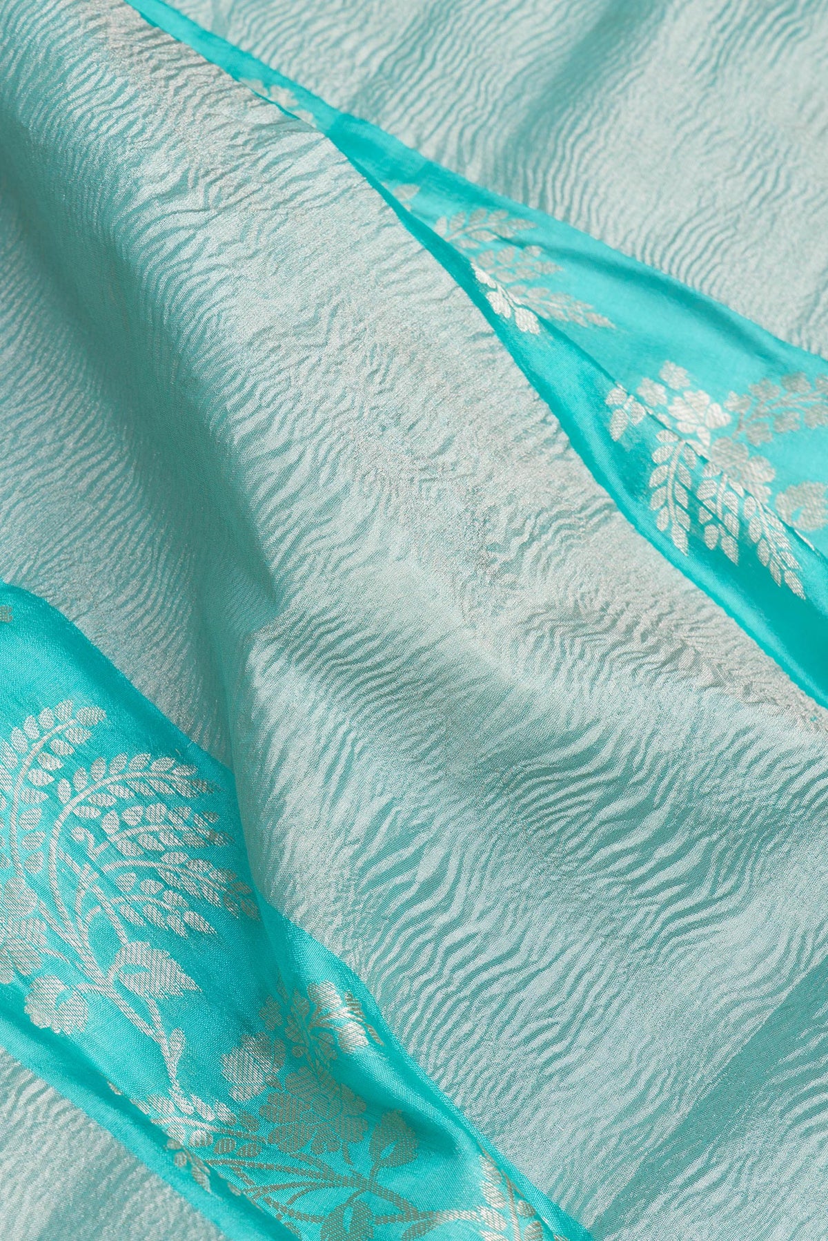 Close up of Sky Blue Tussar Silk Saree with Zari Brocade on the body and Fancy Border.  displaying folds