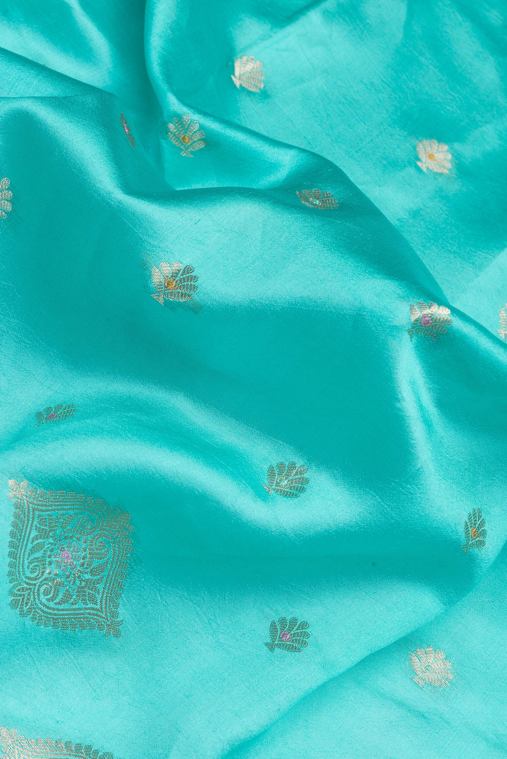 Close up of Sky Blue Tussar Silk Saree with Zari Butta on the body and Fancy Border.  displaying folds