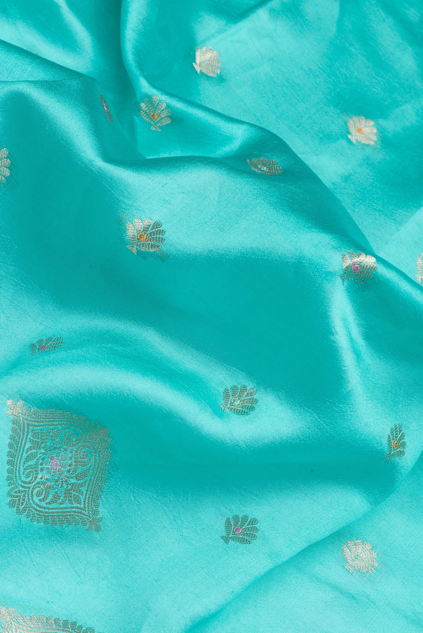 Close up of Sky Blue Tussar Silk Saree with Zari Butta on the body and Fancy Border.  displaying folds