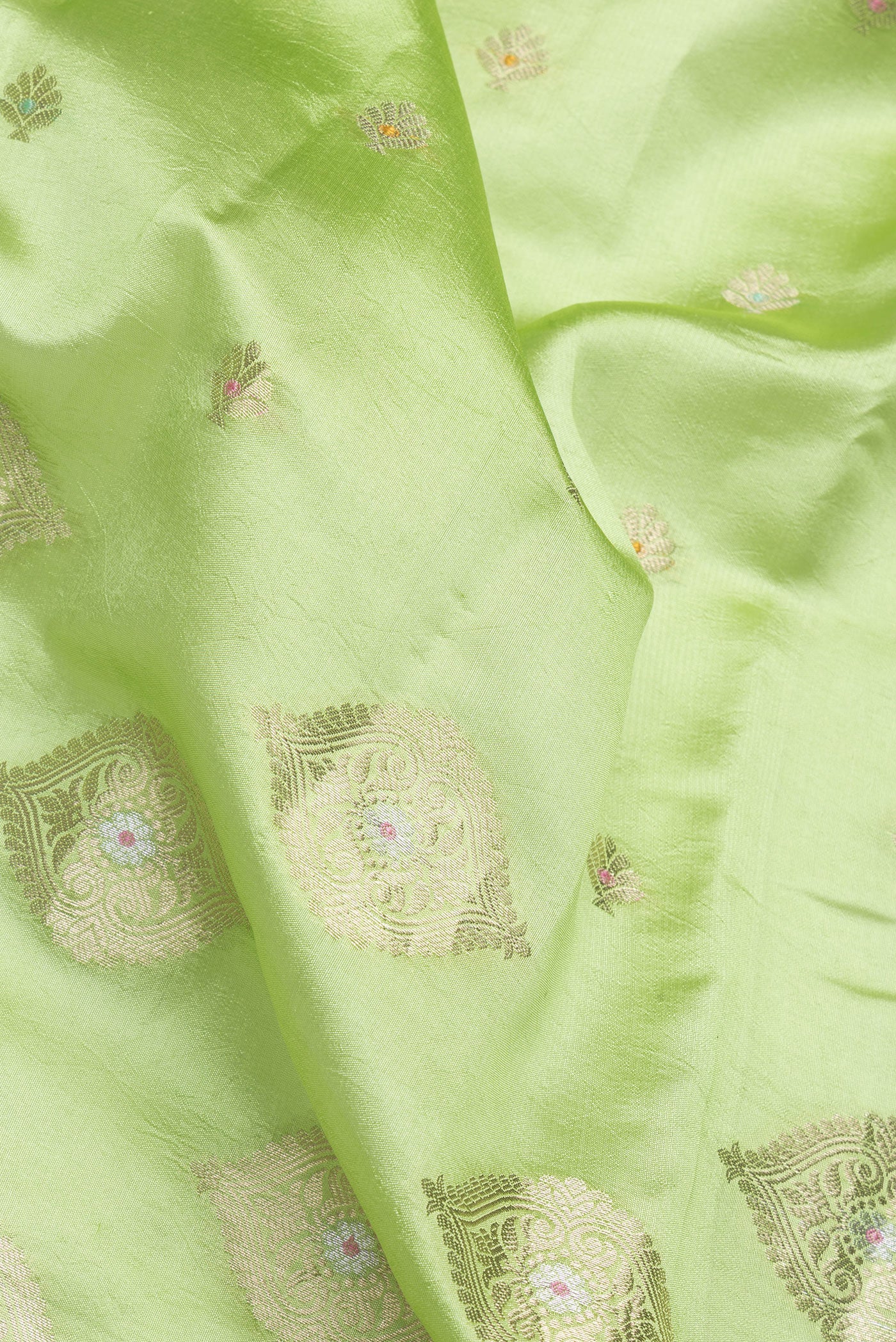 Close up of Parrot Green Dual Tone Tussar Silk Saree with Zari Butta on the body and Fancy Border.  displaying folds
