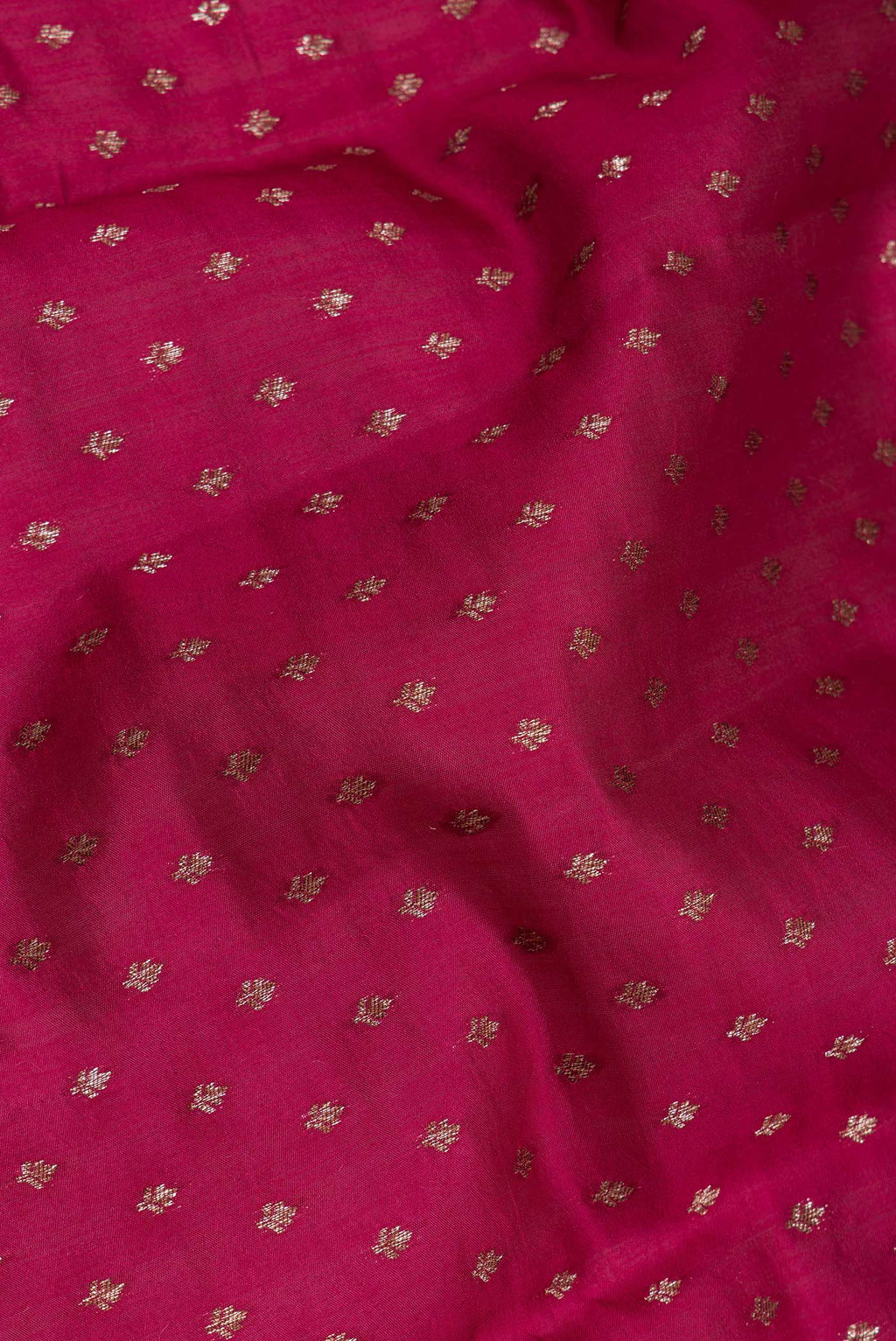 Close up of Dark Pink Tussar Silk Saree with Zari Butta on the body and Zari Border.  displaying folds