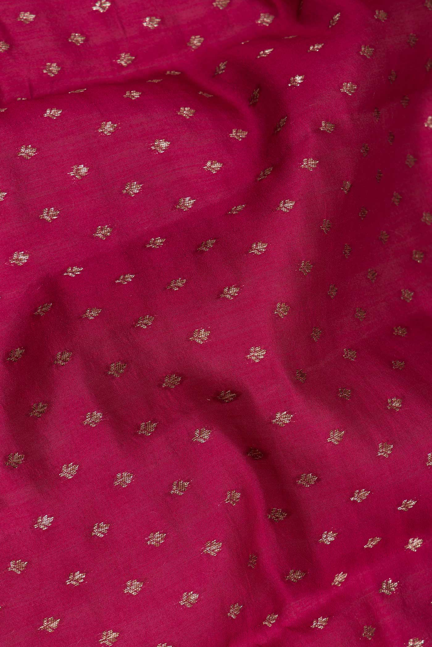 Close up of Dark Pink Tussar Silk Saree with Zari Butta on the body and Zari Border.  displaying folds