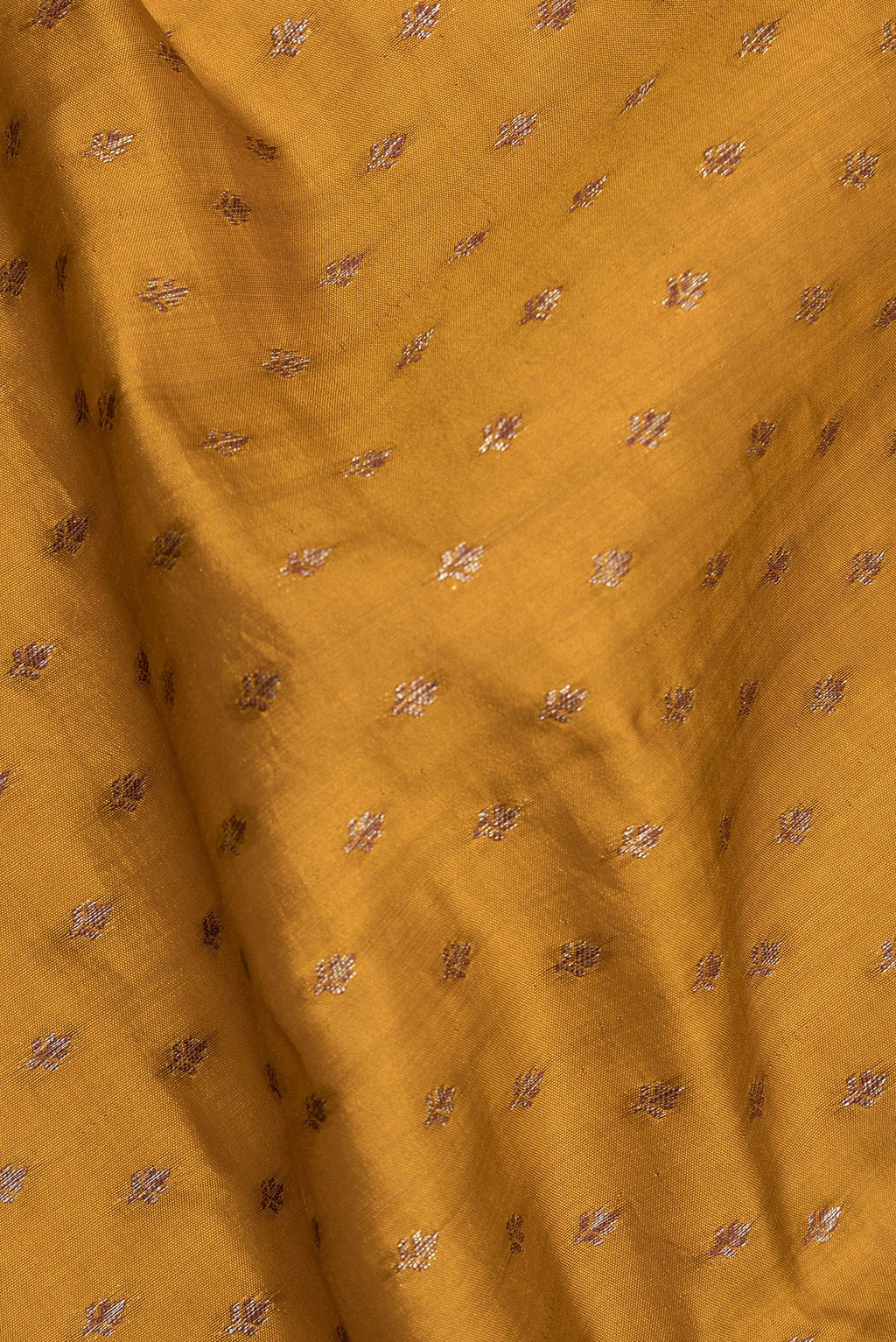 Close up of Pure Silk Mustard Tussar Saree with Zari Butta on the body and Zari Border.  displaying folds