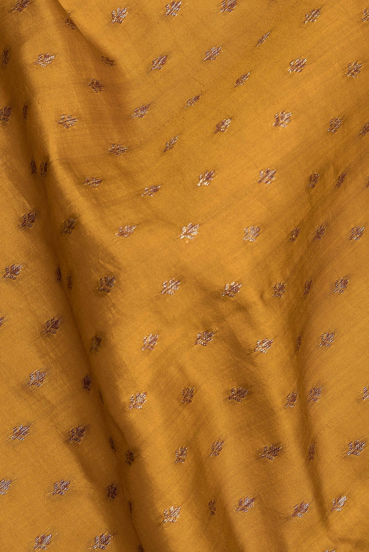 Close up of Pure Silk Mustard Tussar Saree with Zari Butta on the body and Zari Border.  displaying folds