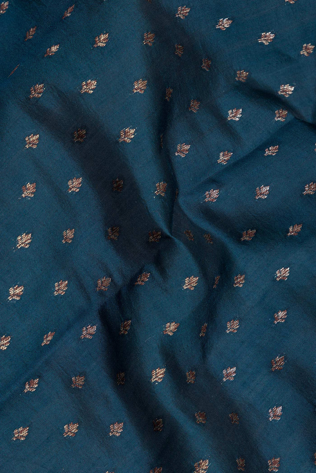 Close up of Peacock Blue Tussar Silk Saree with Zari Butta on the body and Zari Border.  displaying folds