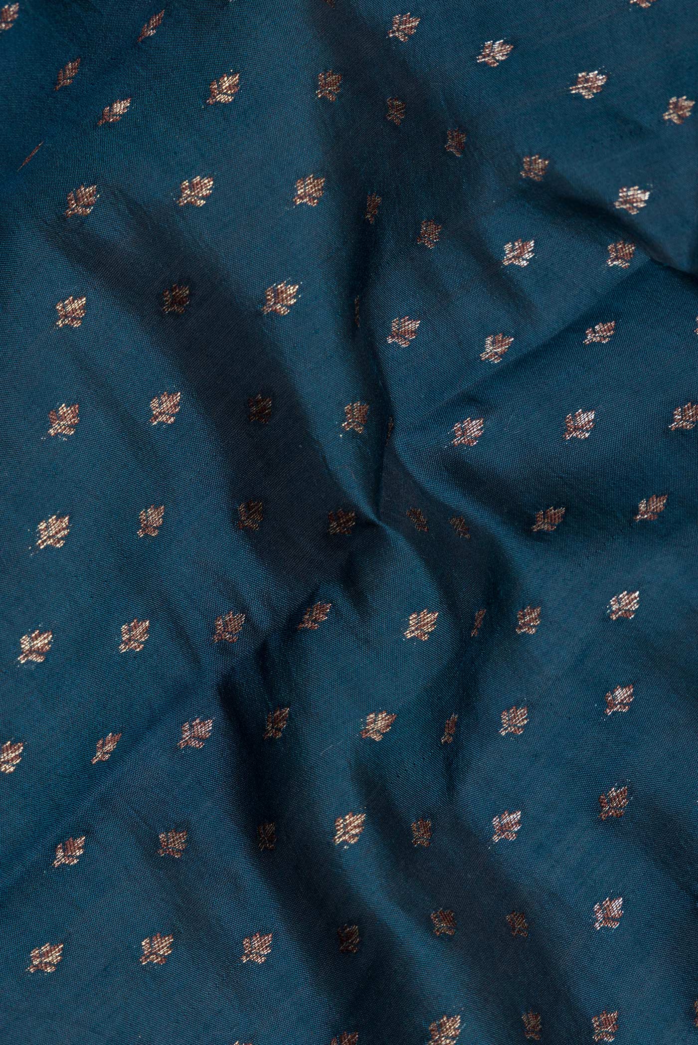 Close up of Peacock Blue Tussar Silk Saree with Zari Butta on the body and Zari Border.  displaying folds