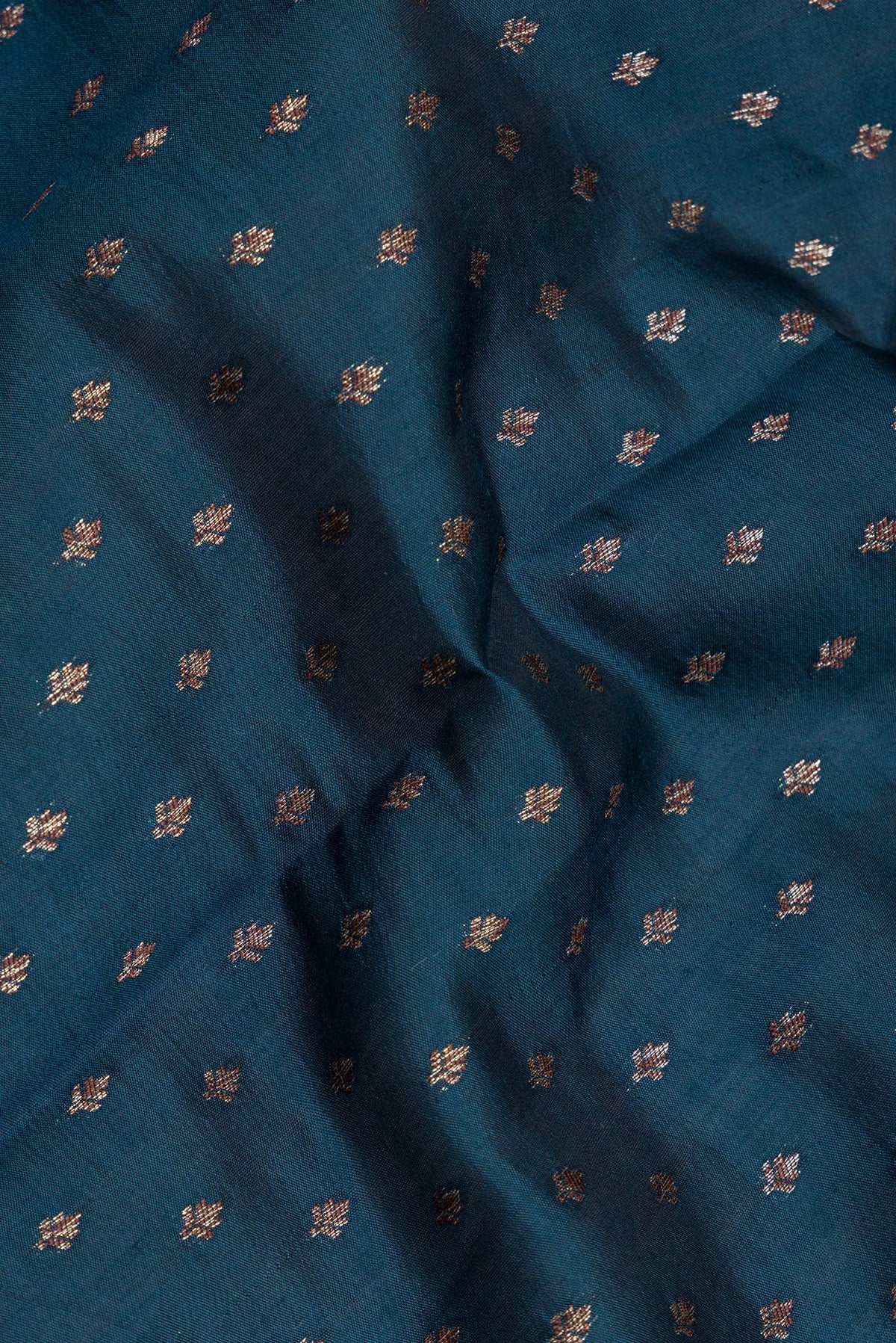 Close up of Peacock Blue Tussar Silk Saree with Zari Butta on the body and Zari Border.  displaying folds