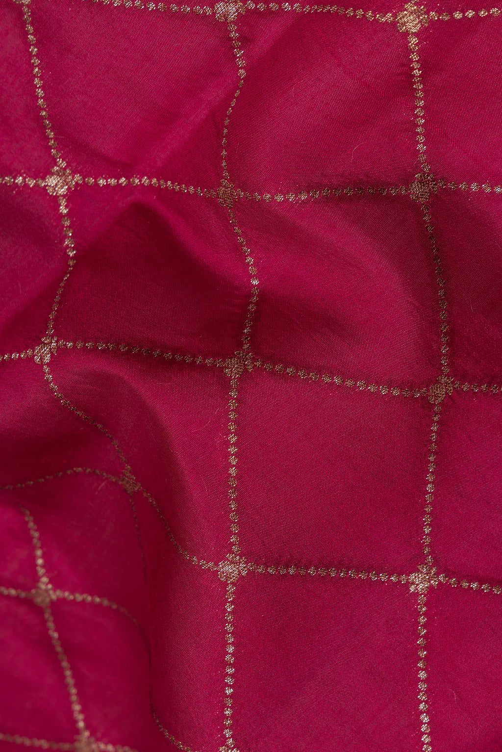 Close up of Dark Pink Tussar Silk Saree with Zari Butta on the body and Zari Border.  displaying folds