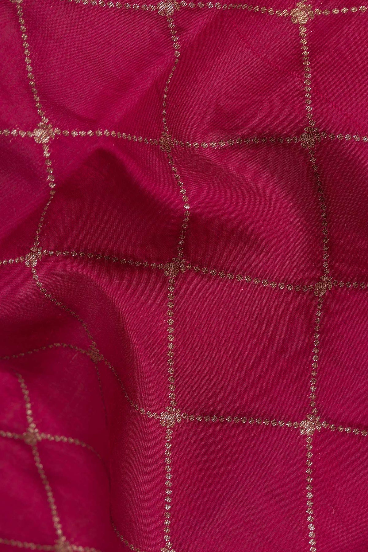 Close up of Dark Pink Tussar Silk Saree with Zari Butta on the body and Zari Border.  displaying folds
