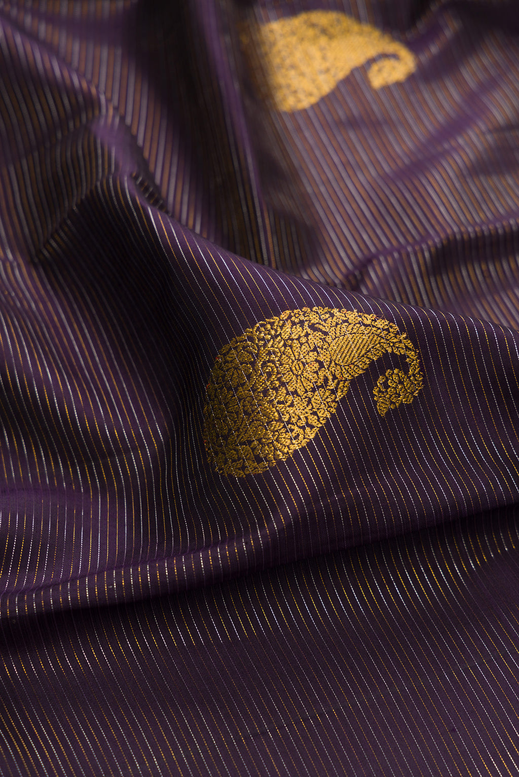 Close up of Pure Silk Purple Kanchipuram Saree with Zari Butta on the body and Fancy Border.  displaying folds