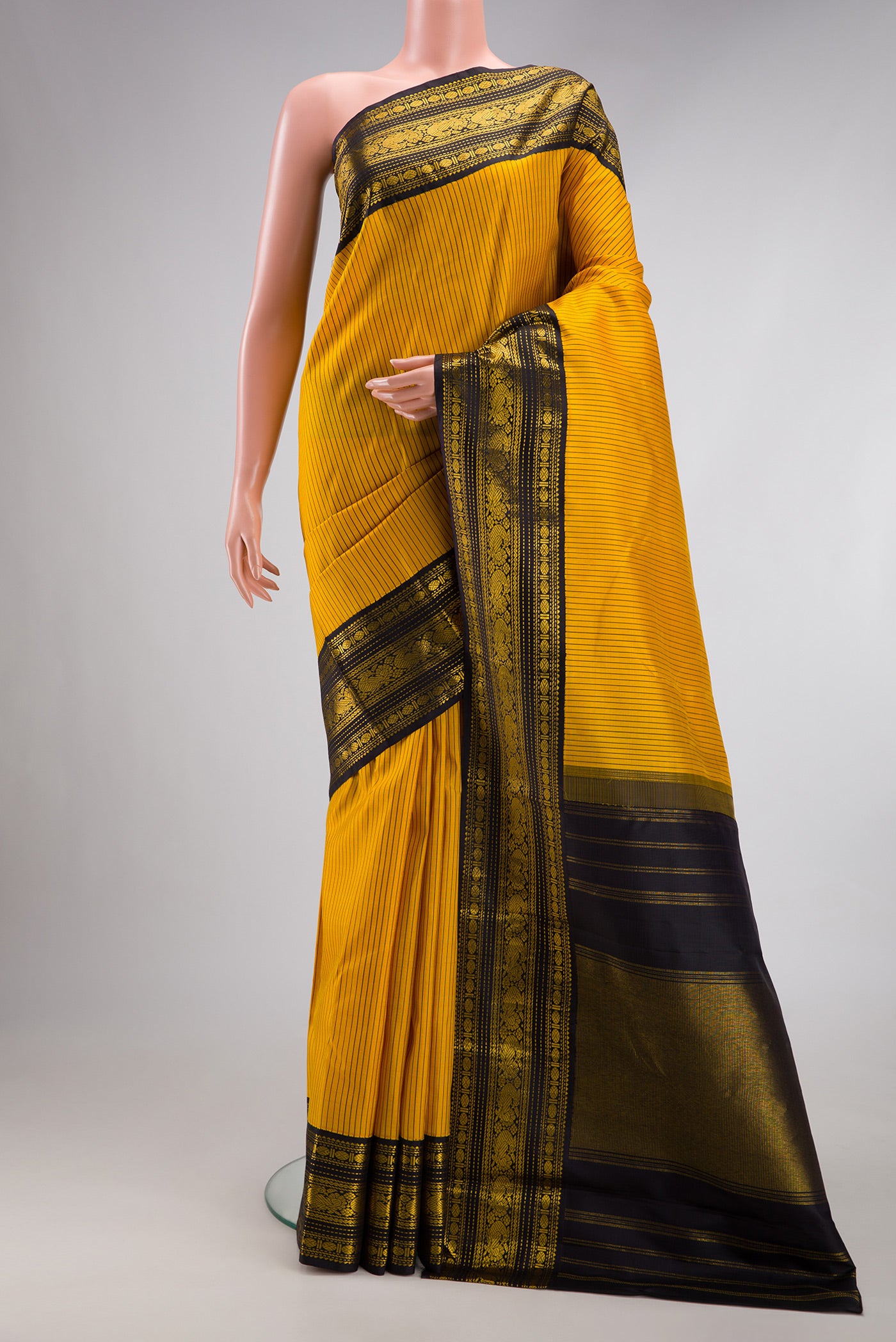 Yellow Kanjivaram Silk Saree with Stripes on the body and Zari Border.  displayed on a mannequin