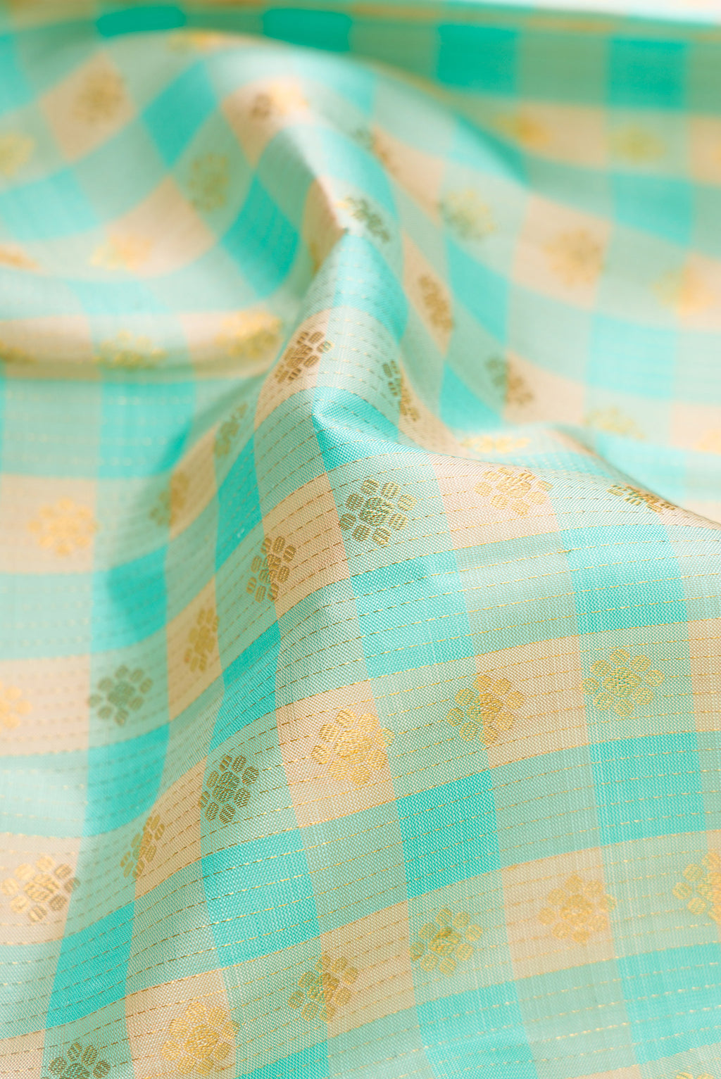 Close up of Sky Blue Kanchipuram Silk Saree with Checked design on the body and Zari Border.  displaying folds