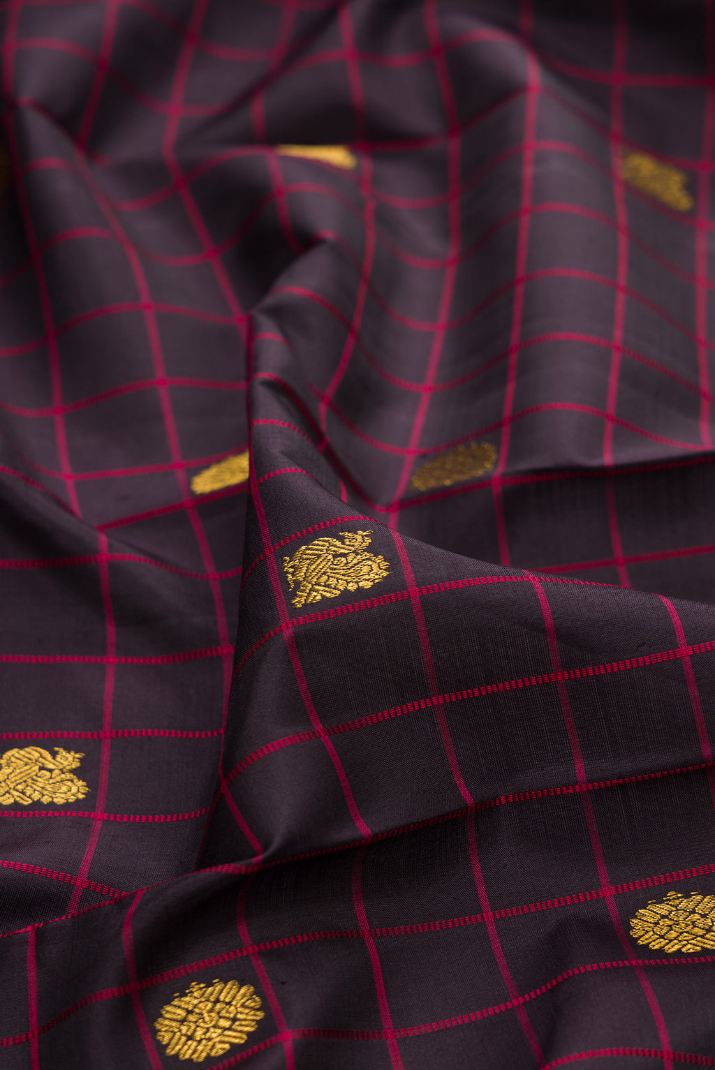 Close up of Pure Silk Brown Kanjivaram Saree with Checked design on the body and Plain Border.  displaying folds