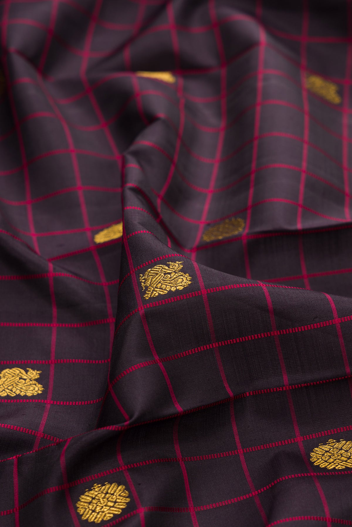 Close up of Pure Silk Brown Kanjivaram Saree with Checked design on the body and Plain Border.  displaying folds