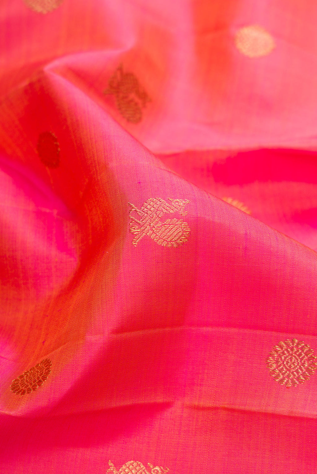 Close up of Pure Silk Pure Zari Pink Dual Tone Kanjivaram Saree with Zari Butta on the body and Zari Border.  displaying folds