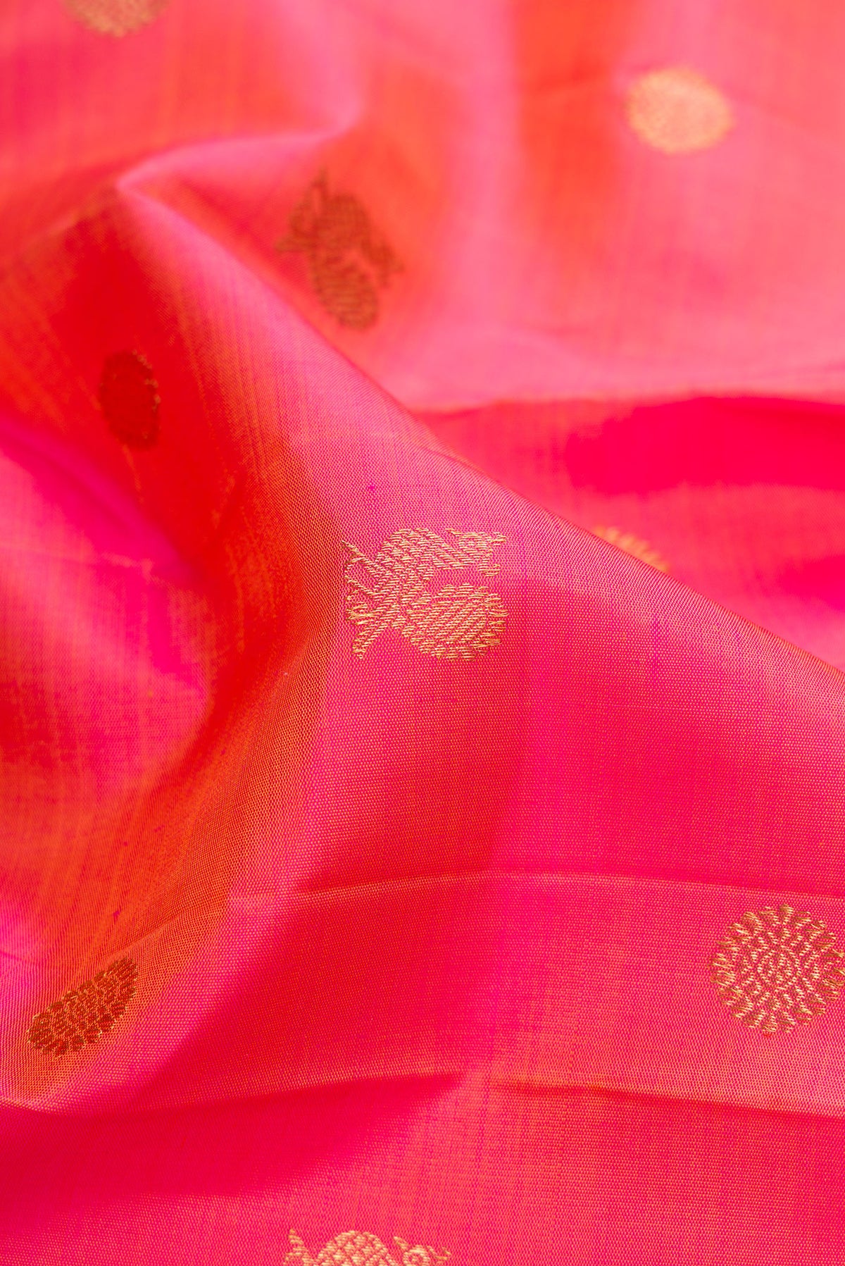 Close up of Pure Silk Pure Zari Pink Dual Tone Kanjivaram Saree with Zari Butta on the body and Zari Border.  displaying folds