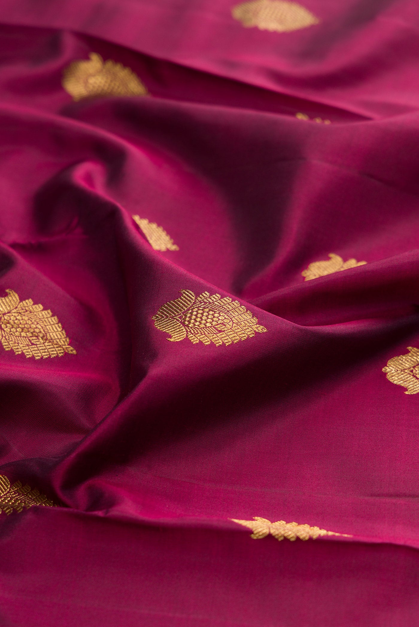 Close up of Pure Silk Pure Zari Maroon Kanjivaram Saree with Zari Butta on the body and Zari Border.  displaying folds