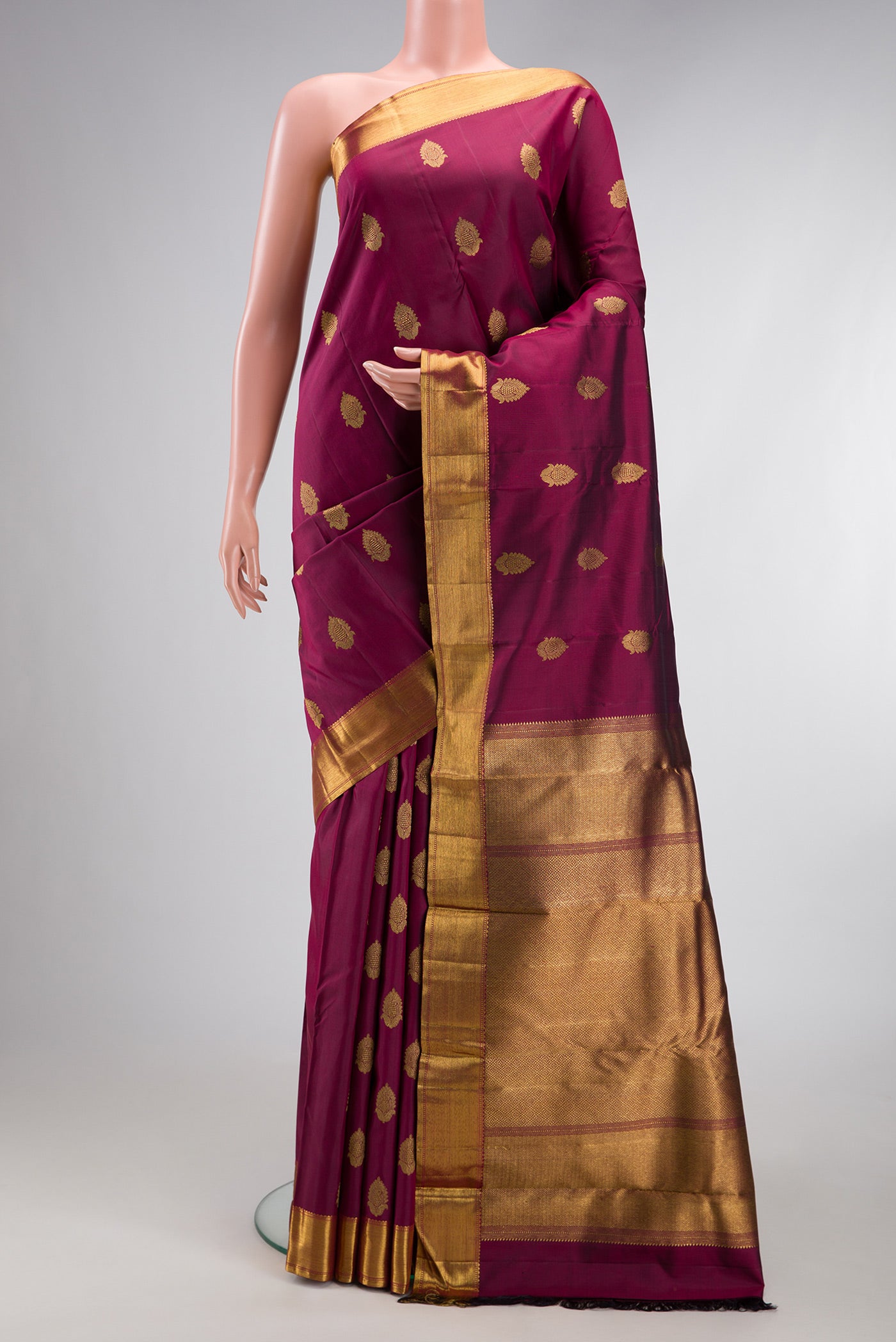 Pure Silk Pure Zari Maroon Kanjivaram Saree with Zari Butta on the body and Zari Border.  displayed on a mannequin