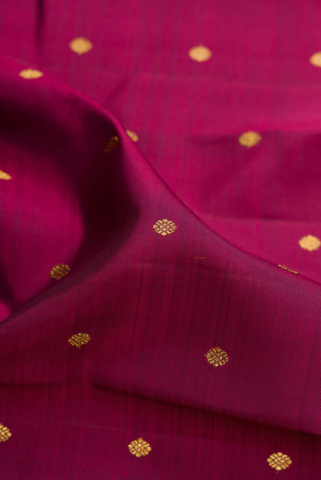 Close up of Pure Silk Pure Zari Maroon Dual Tone Kanjivaram Saree with Zari Butta on the body and Zari Border.  displaying folds
