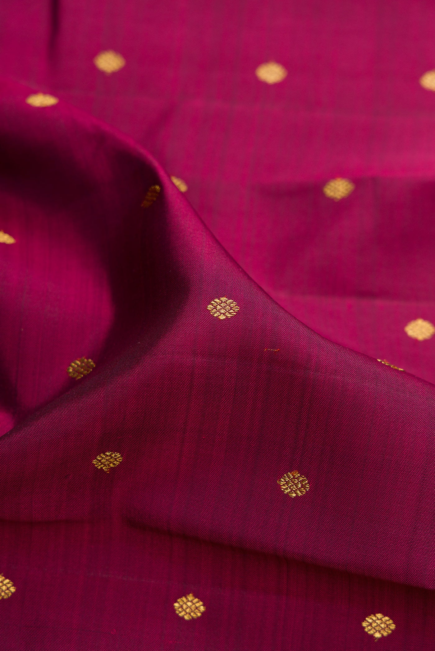 Close up of Pure Silk Pure Zari Maroon Dual Tone Kanjivaram Saree with Zari Butta on the body and Zari Border.  displaying folds
