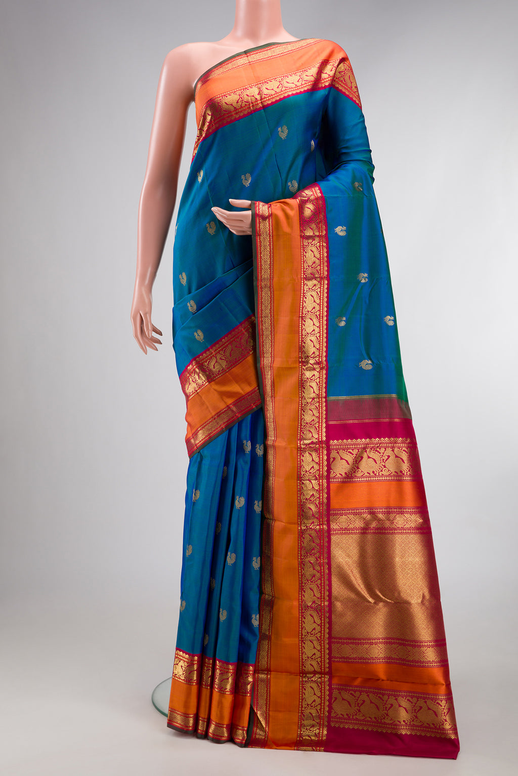 Pure Silk Pure Zari Peacock Blue Kanjivaram Saree with Zari Butta on the body and Zari Border.  displayed on a mannequin