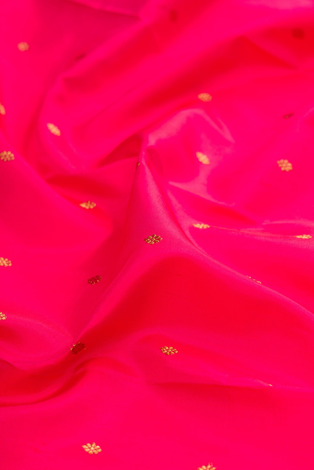 Close up of Pure Silk Pure Zari Dark Pink Kanjivaram Saree with Zari Butta on the body and Zari Border.  displaying folds