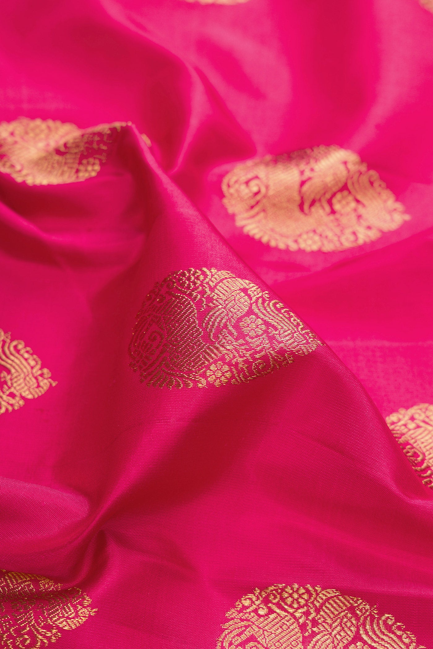 Close up of Pure Silk Pure Zari Pink Kanjivaram Saree with Zari Butta on the body and Fancy Border.  displaying folds