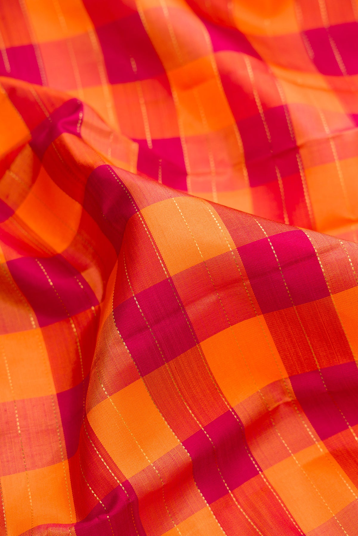 Close up of Pure Silk Pure Zari Orange and Maroon Dual Tone Kanjivaram Saree with Checked design on the body and Zari Border.  displaying folds