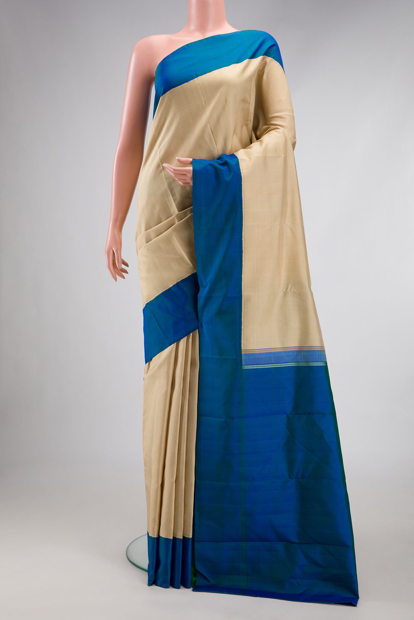 Beige Kanjivaram Silk Saree with Checked design on the body and Plain Border.  displayed on a mannequin