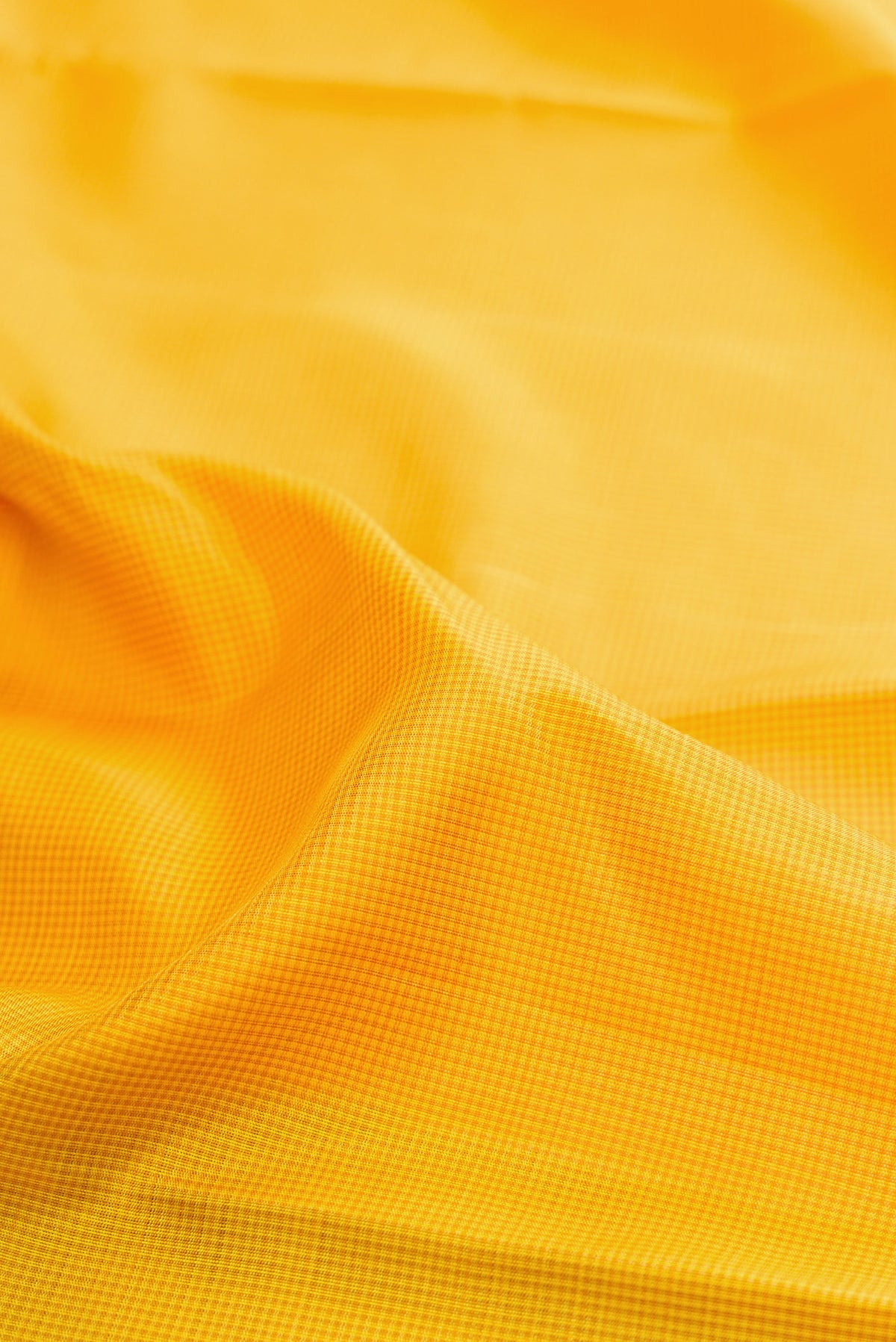Close up of Yellow Kanjivaram Silk Saree with Checked design on the body and Temple Border.  displaying folds