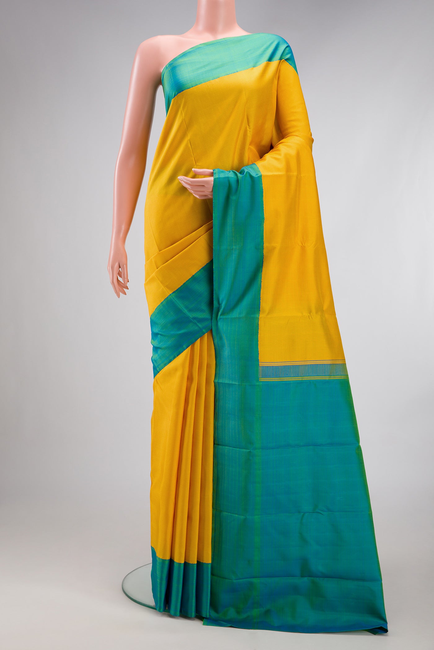 Yellow Kanjivaram Silk Saree with Checked design on the body and Plain Border.  displayed on a mannequin