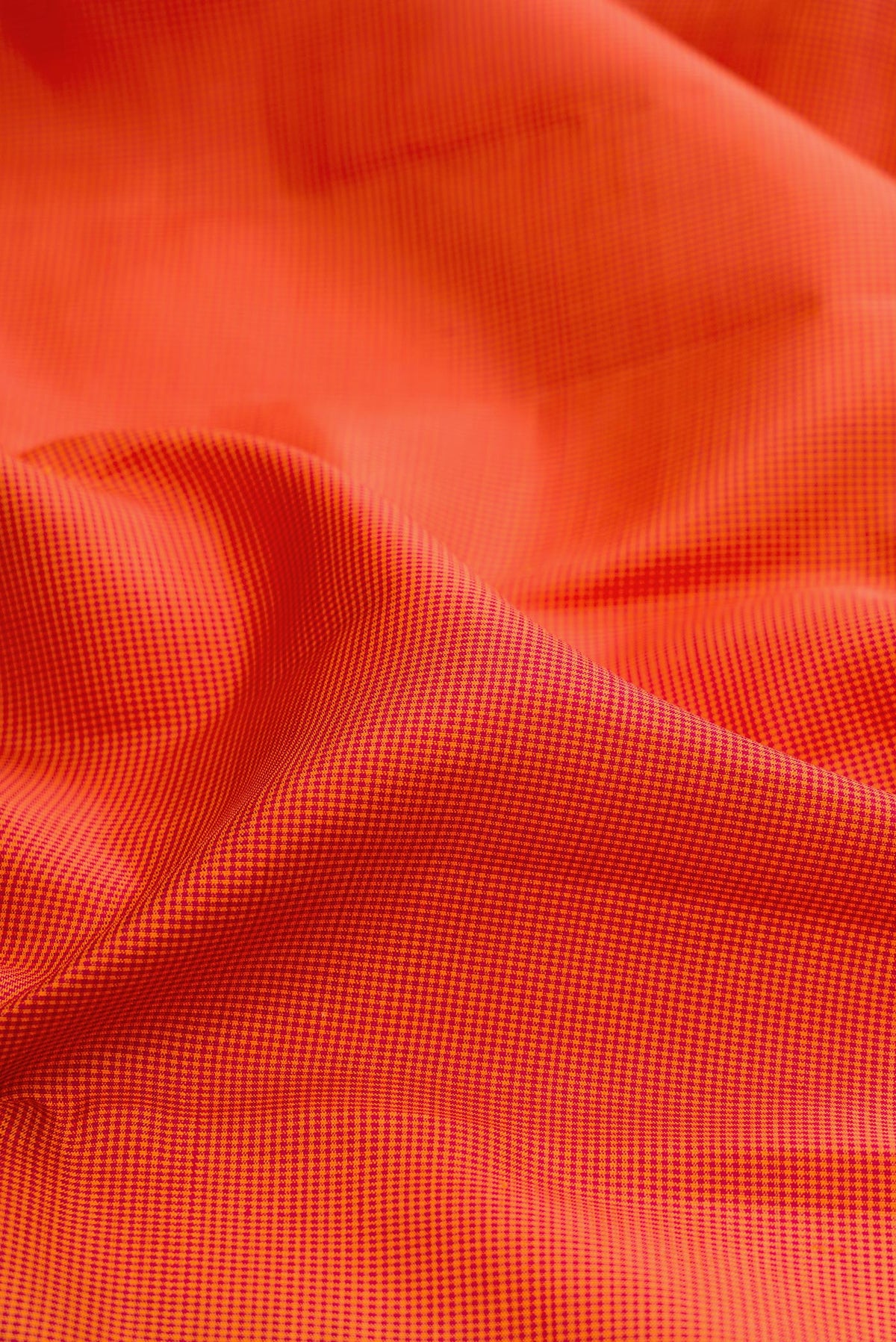 Close up of Brick Orange Kanjivaram Silk Saree with Checked design on the body and Temple Border.  displaying folds