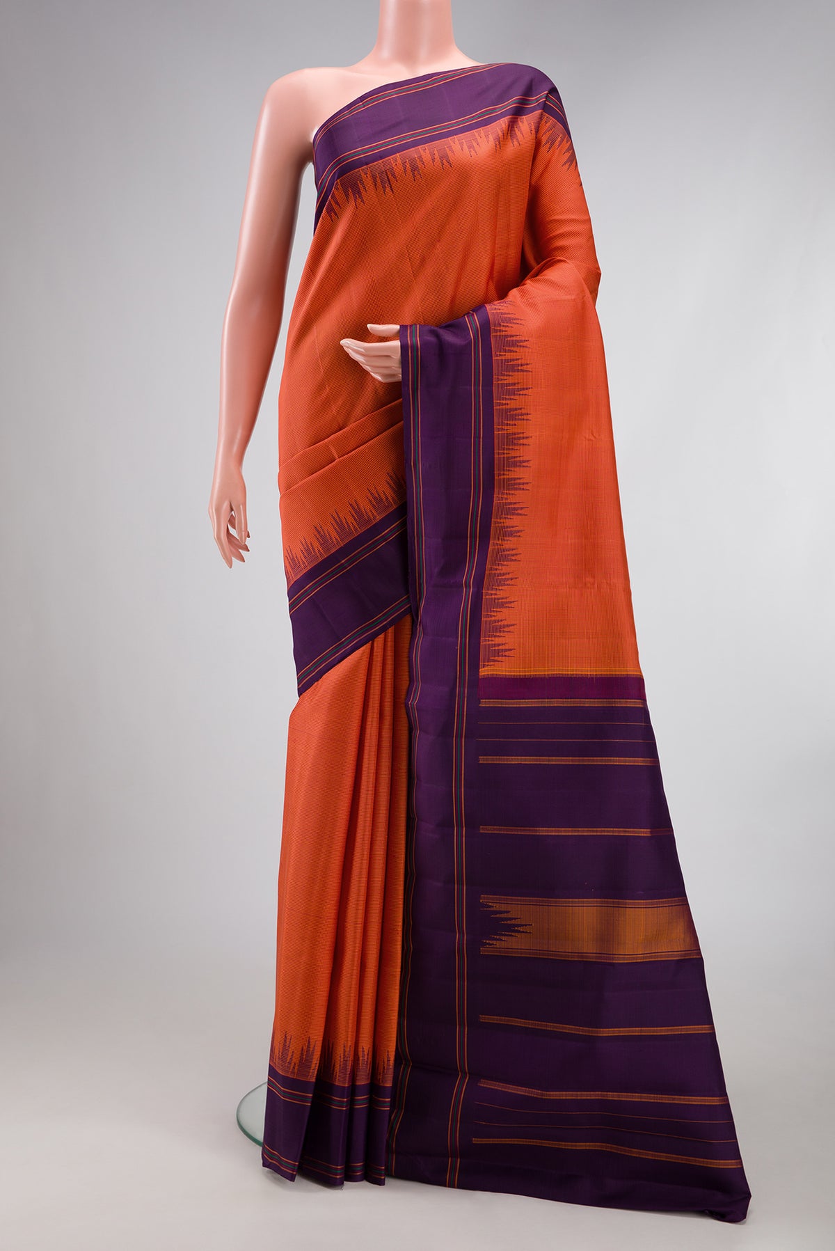 Brick Orange Kanjivaram Silk Saree with Checked design on the body and Temple Border.  displayed on a mannequin