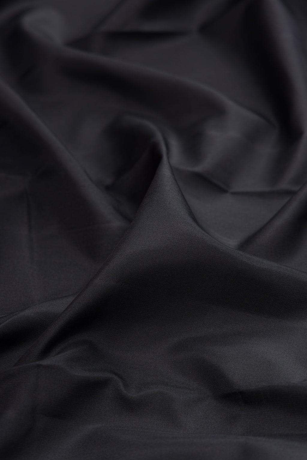 Close up of Pure Silk Pure Zari Black Kanjivaram Saree with Plain Body and Fancy Border.  displaying folds