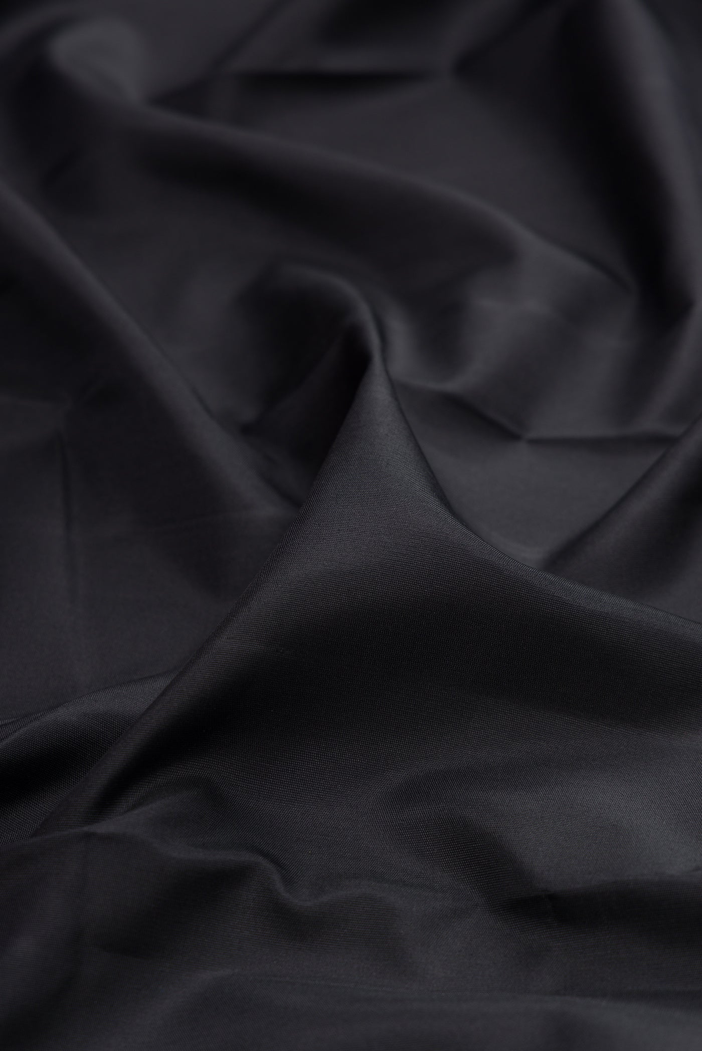 Close up of Pure Silk Pure Zari Black Kanjivaram Saree with Plain Body and Fancy Border.  displaying folds