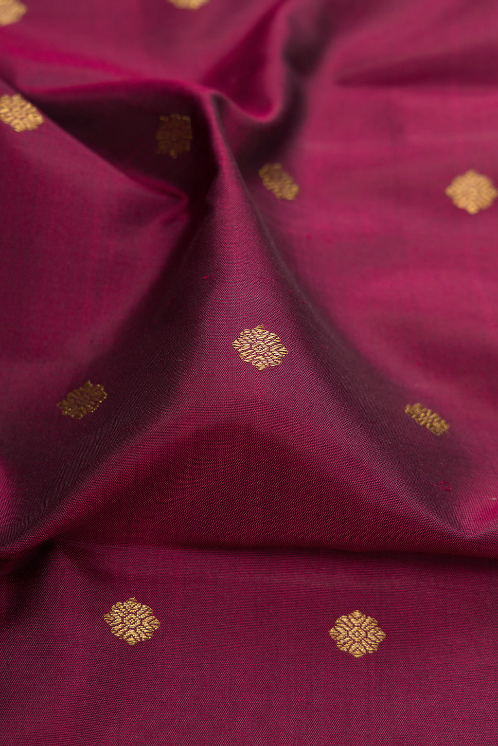 Close up of Pure Silk Pure Zari Maroon Kanjivaram Saree with Zari Butta on the body and Fancy Border.  displaying folds