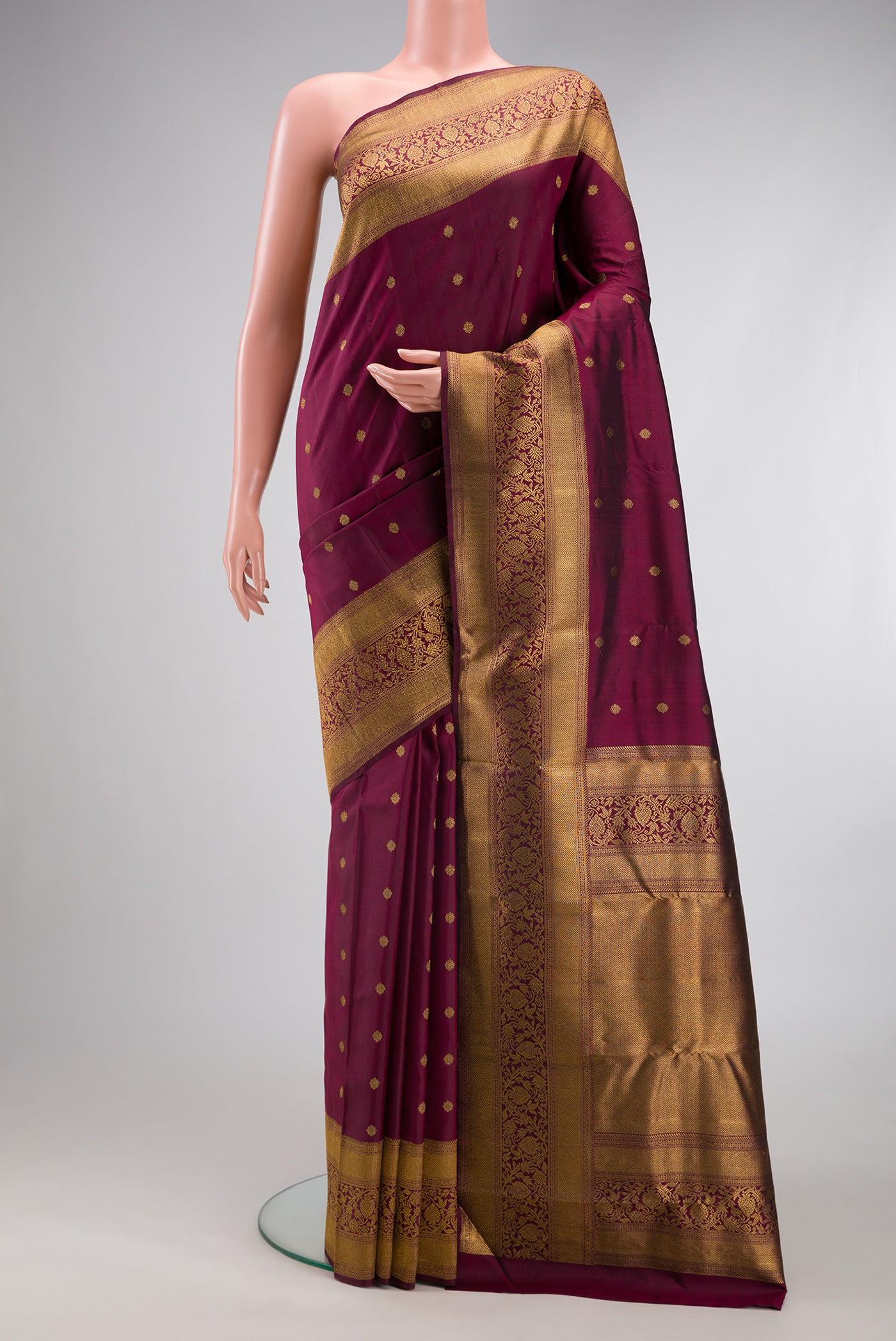 Pure Silk Pure Zari Maroon Kanjivaram Saree with Zari Butta on the body and Fancy Border.  displayed on a mannequin